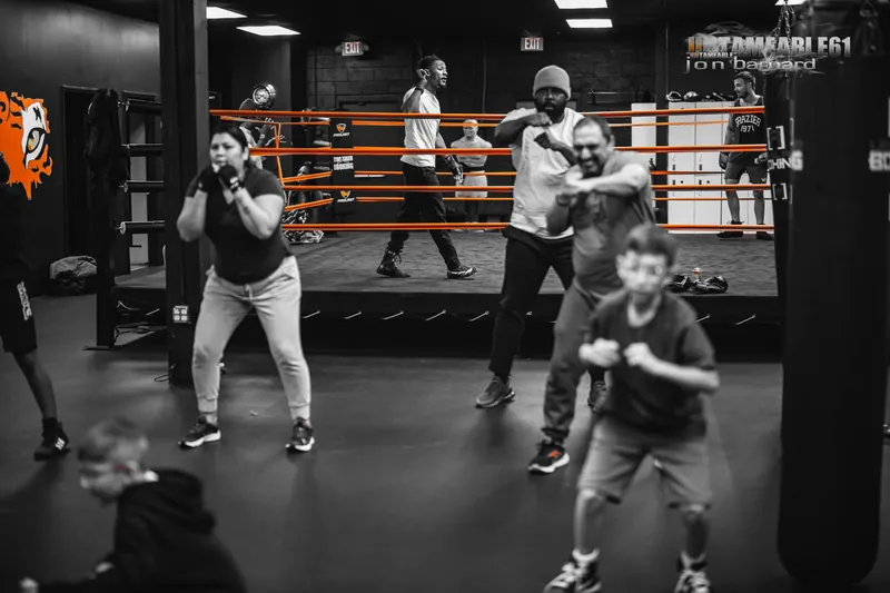 Adults and kids shadowboxing in a group class