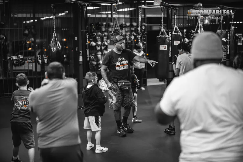 Coach directing a kids class by the glove wall