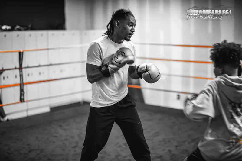 Coach in boxing gloves demonstrating a punch
